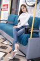 A woman sitting on a blue couch in a train.