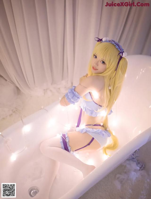 A woman sitting in a bathtub with lights around her.