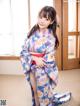 A woman in a blue and pink kimono posing for a picture.