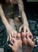 A man and a woman in a bathtub with their feet in the water.