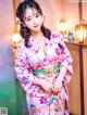 A woman in a pink kimono posing for a picture.