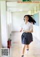 A young woman in a school uniform running down a hallway.