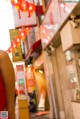 A woman in a red dress standing in front of a store.