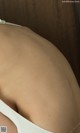 A close up of a woman's butt in a white bra.