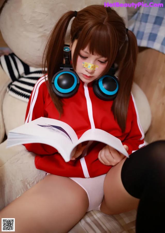 A woman sitting on a couch reading a book.