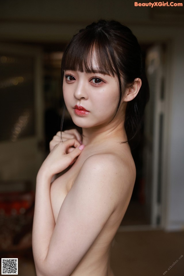 A naked asian woman posing for the camera. 