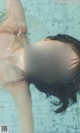 A woman in a swimming pool smiling at the camera.