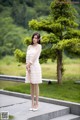 A woman in a white dress standing on some steps.