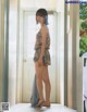 A woman standing in front of a door in a room.